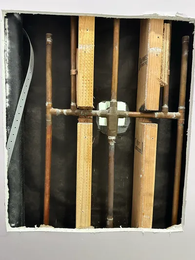 New copper supply risers run through an open wall cavity during a repipe