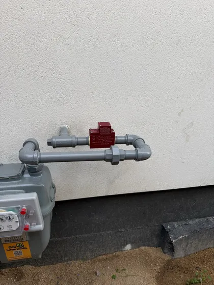 An earthquake-actuated seismic gas shut-off valve installed downstream of a residential gas meter
