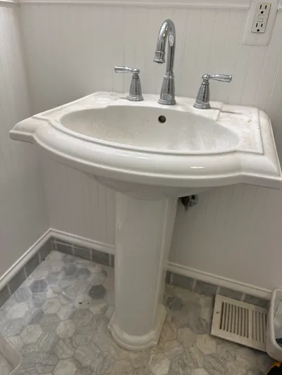 A pedestal sink installed with new angle stops and supply connections