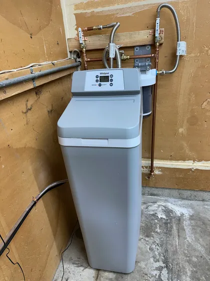 A whole-house water treatment system installed with copper manifold and bypass valves in a Bay Area garage